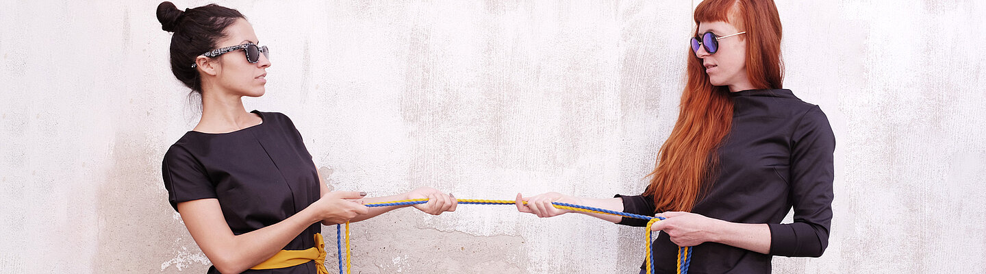 zwei junge Frauen ziehen an einem Strang